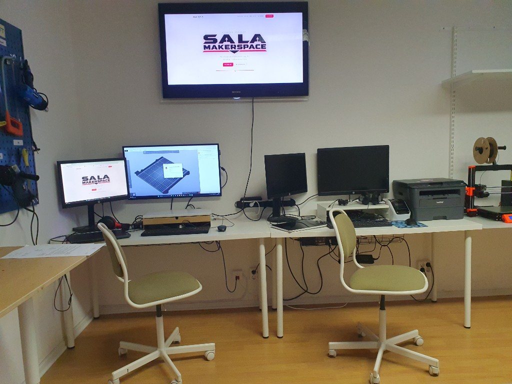 Datorhubben med flera skärmar, PrusaSlicer och Sala Makerspace-loggan på väggen